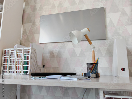 Desk for student with lamp, notebook and supplies. Modern home office workstation interior for remote learning or studying. Organized workspace with stationery for educational task.