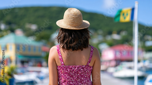 Woman in Straw Hat Walking through Bequia Waterfront with Saint Vincent and the Grenadines Flag