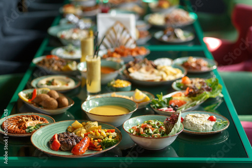 Wide Array Of Communal Dining Offerings Displayed. Multiple Platters And Bowls Showcasing Festive Food Presentation
