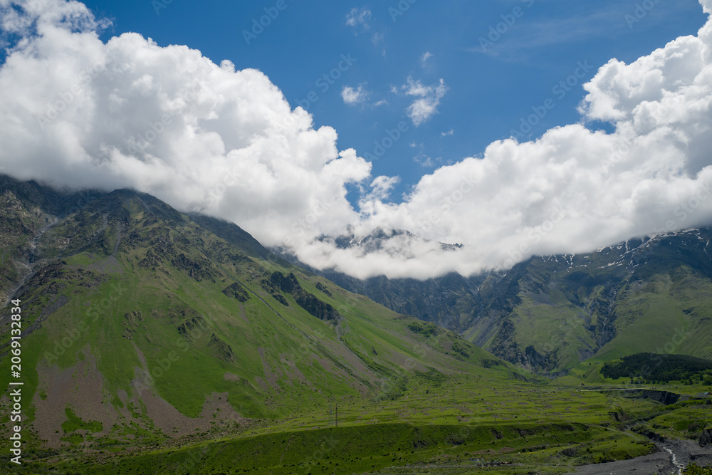 Fototapeta premium A picturesque mountain landscape in the Kazbegi region of Georgia. This region is famous for its high peaks, alpine meadows, and popular hiking trails.