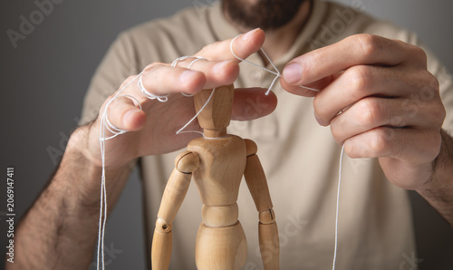 Bild auf Leinwand Man controls the action wooden marionette.