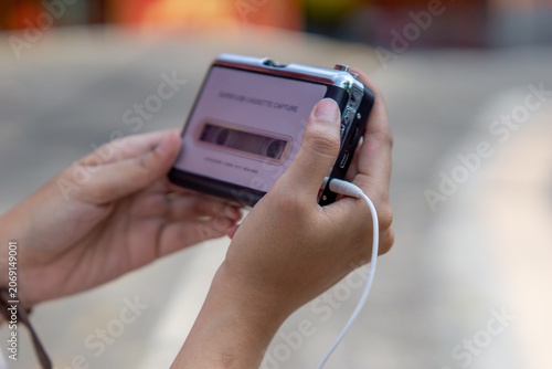 Hand holding a walkman. A device for listening to old music stored on cassettes.