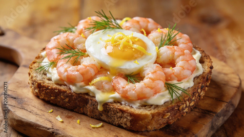 Open-faced gourmet shrimp toast topped with boiled egg and creamy spread, served as a fresh seafood breakfast or appetizer.