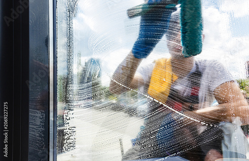 Fotografía Professional window cleaner applying soapy suds to glass with a squeegee