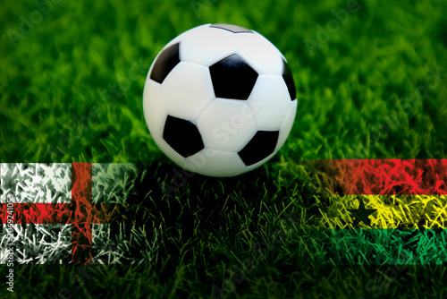 Soccer ball with 2 nation flags on green grass; England vs Ghana; Soccer football tournament