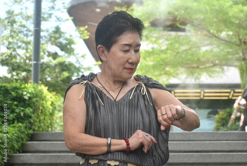 Fototapeta premium elder woman strong and healthy posing and smiling in community mall garden