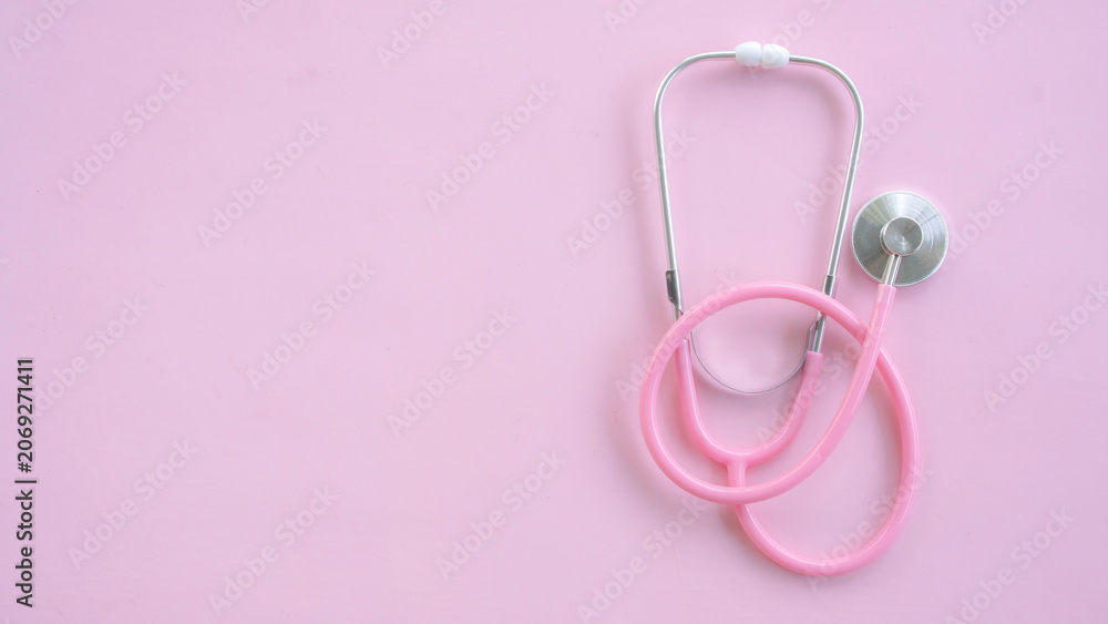 Fototapeta premium Minimal medical background with pink stethoscope placed on the right side of pink canvas