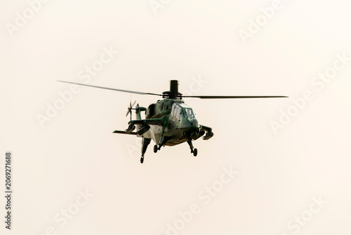Military helicopter is flying on isolated white background