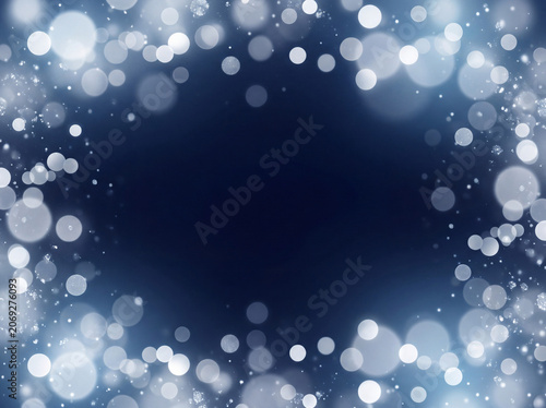 Glowing abstract white bokeh lights on dark blue background