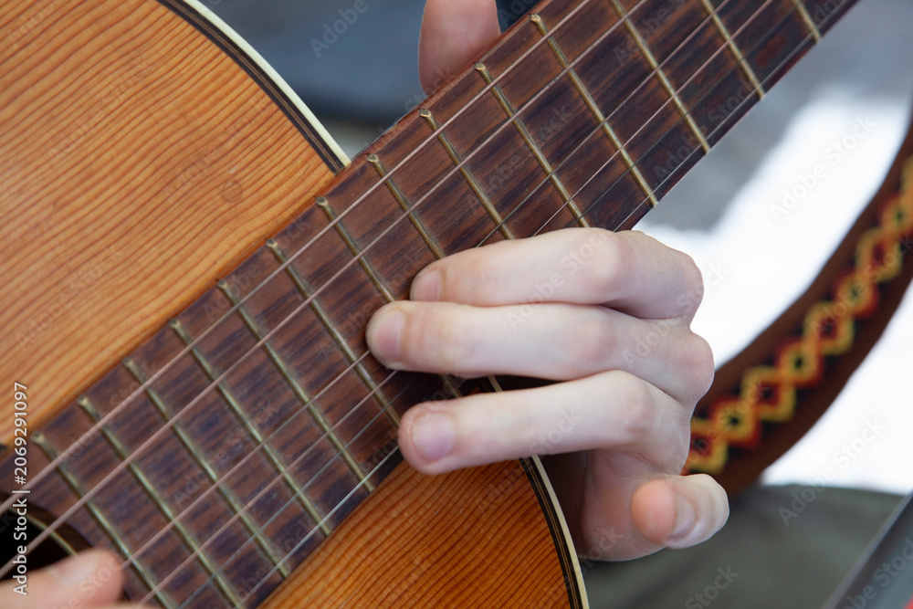 Fototapeta premium A man plays the guitar. Close-up of his hands