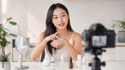 Cosmetic expert presenting a skincare cream during a recorded beauty science demonstration, useful for product marketing and educational content.