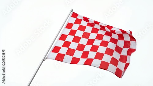Red and white checkered racing flag waving against white sky