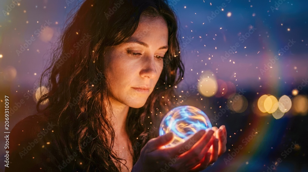 Naklejka premium Woman holding glowing crystal ball at night.