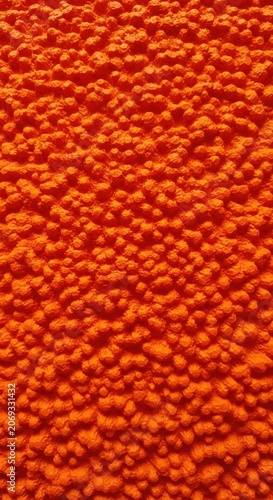 Vibrant orange textured background of small round objects.