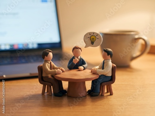 Miniature Claymation Businessmen Having Brainstorming Session Around Table Creative Office Diorama