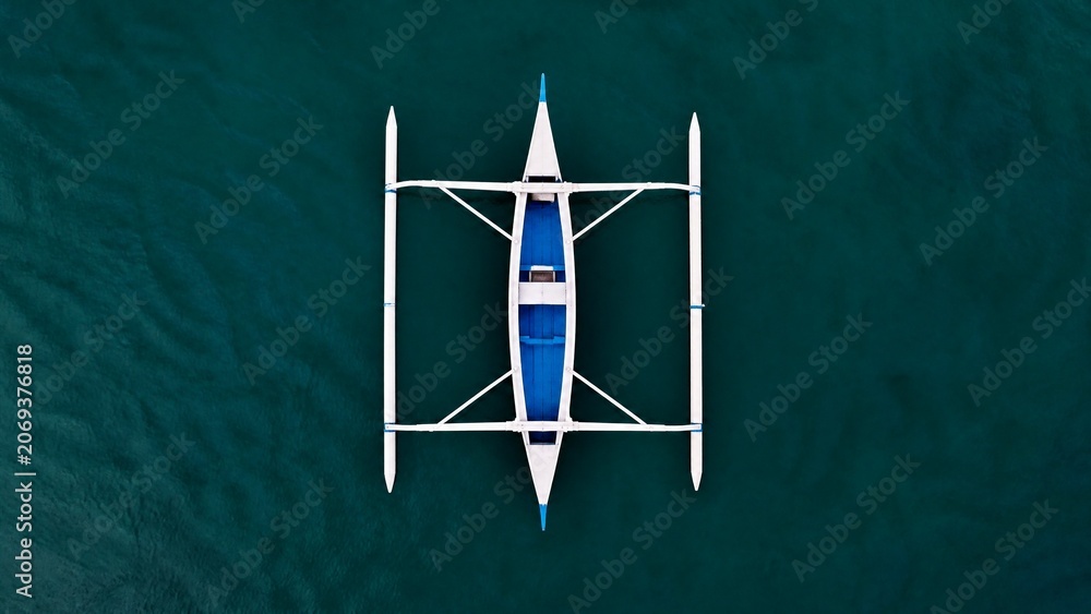 Obraz premium Top-down view of a boat hull with symmetrical outriggers on calm water, minimalist geometric shape.