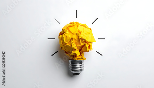 Yellow crumpled paper light bulb symbolizing a new idea, innovation, brainstorming, and creativity against a plain background