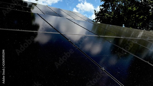 Solar Panels Reflecting Blue Sky and Clouds, Renewable Energy Concept, Clean Electricity Technology
