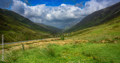фотографія Glen Docherty stretches between towering hills under a cloudy sky showcasing the