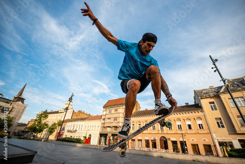 фотографія Skater performing kickflip trick in urban square