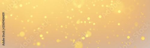 Golden glitter particles banner with soft bokeh lights on warm background