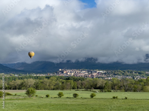Hot air balloon flying over Puigcerda town in Catalonia