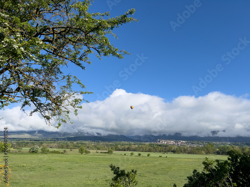 Hot air balloon crossing rural landscape near Puigcerda