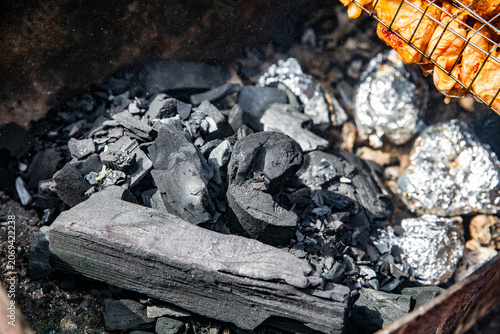 Foto Appetizing kebabs on skewers over charcoal in a barbecue grill in nature