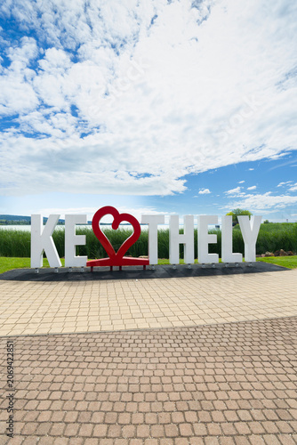 Keszthely sign with heart symbol against Lake Balaton