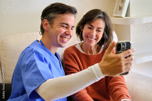 Fotografie close up of Caregiver and senior woman taking a joyful selfie