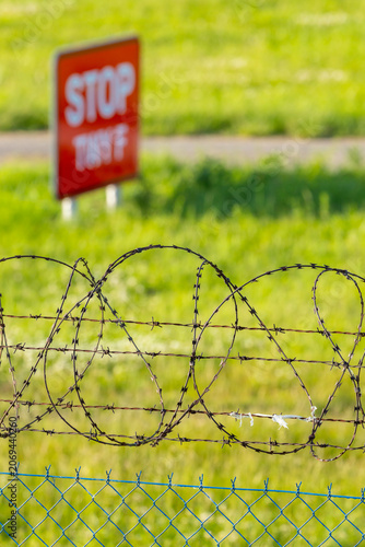 Barbed wire fence and stop sign restricting access