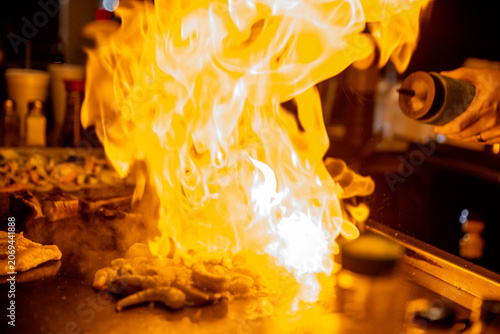 Hibachi chef spraying sake on the meat
