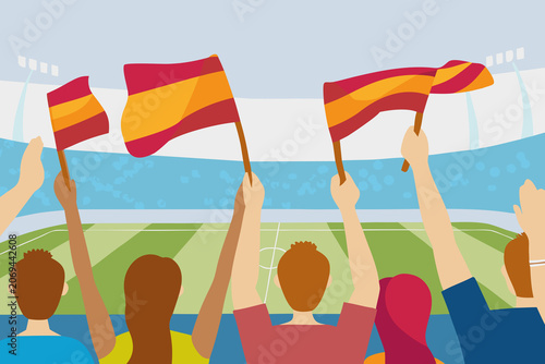 Fans wave Spanish flags while watching a soccer match in a stadium during the day in a crowded sports event
