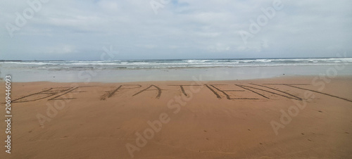 Be patient message written in sand on beach