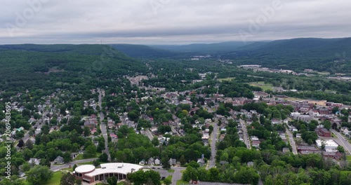 Oneonta, NY, USA - June 7, 2026: Late afternoon spring aerial video of downtown, business district, Oneonta, NY on an overcast day.
