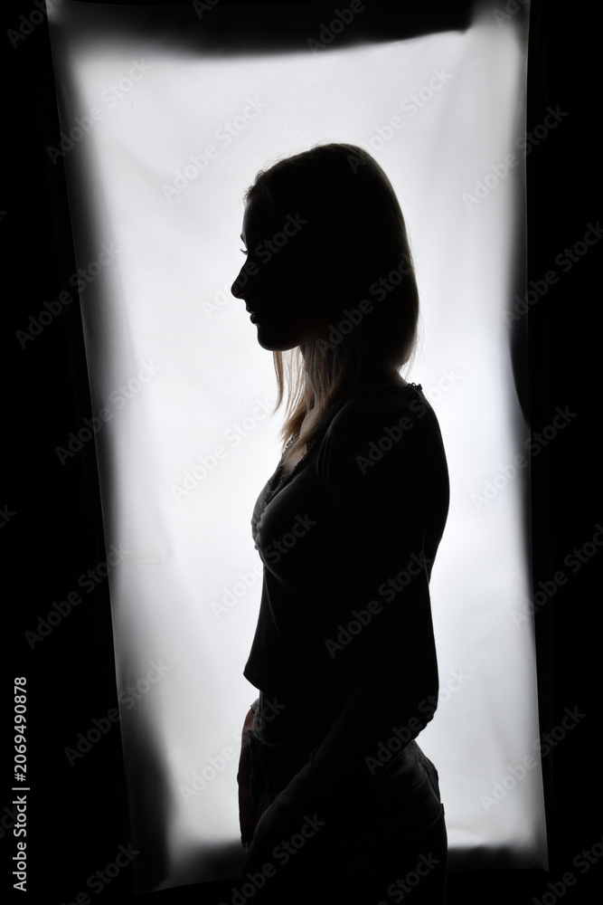 Naklejka premium Silhouette einer Frau vor hellem Hintergrund. Ausdrucksstarkes People-Motiv für Identität, Selbstreflexion, mentale Gesundheit, Achtsamkeit, Persönlichkeit und innere Stärke.