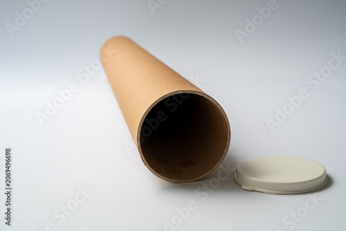 Fotografie Single cardboard mailing tube standing upright on a clean neutral background, commonly used for shipping posters, documents, blueprints, and protective packaging