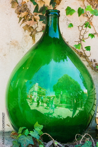 Close‑Up of Green Bulbous Glass Bottle with Ivy