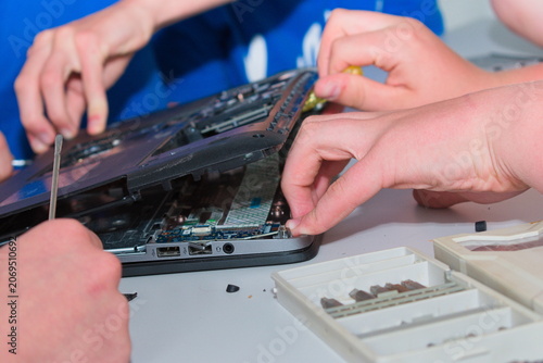 Hands opening laptop for hardware repair