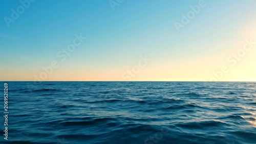 Calm blue ocean waves under a clear sunset sky