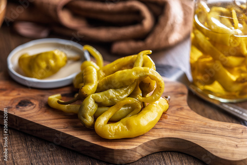 Pickled Banana Peppers On A Wooden Board .Rustic Preserved Snack