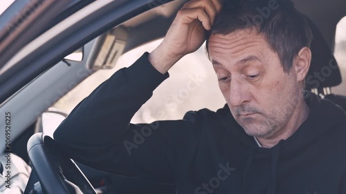 Closeup of mature adult male driver sitting in car and waiting, 4K