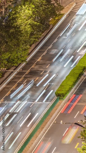 Urban nighttime road traffic flow light trail time-lapse video