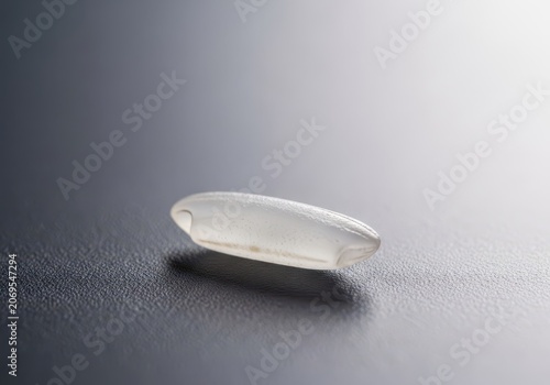 Macro shot highlighting the texture and purity of a singular, uncooked grain of white rice resting on a clean, solid surface, crop, staple, farming