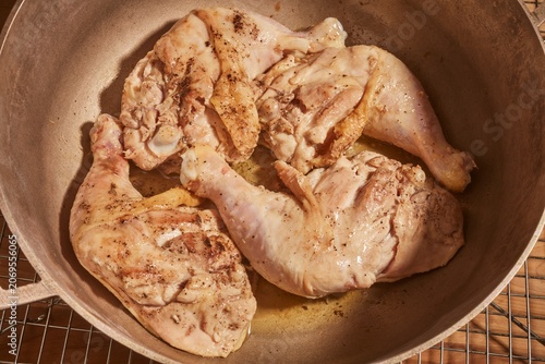 Whole chicken legs and thighs browning in a pot.