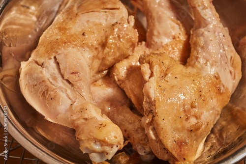 Browned whole chicken legs in a steel bowl.
