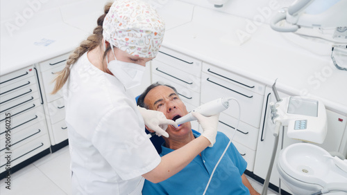 Dentist performing digital scanning on a patient's teeth in a modern dental clinic, demonstrating advanced oral care technology
