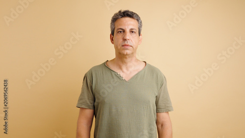 Принти на полотні Serious middle aged man standing, looking directly at camera