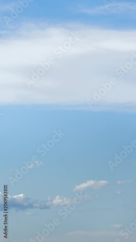 Time-lapse video footage of clouds slowly drifting across the sky on a clear day.