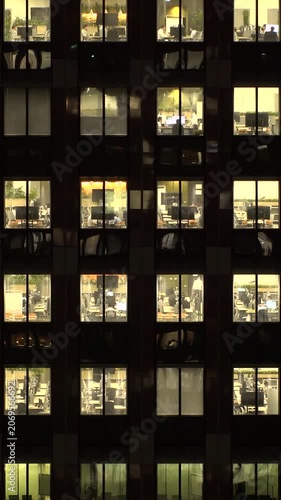 TOKYO, JAPAN : Close up shot of office building window at night. Job, work, company, corporate and business people concept time lapse vertical video.